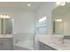 Elegant bathroom with soaking tub, double vanity, and a large mirror at 2137 Sunshine Peak Dr, Minneola, FL 34715
