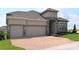 Two-story house with two-car garage and brick accents at 2137 Sunshine Peak Dr, Minneola, FL 34715