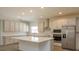 Modern kitchen with white cabinets, center island, and stainless steel appliances at 2137 Sunshine Peak Dr, Minneola, FL 34715