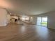 Open-concept living room with modern flooring, a kitchen, and sliding doors to the outside at 2137 Sunshine Peak Dr, Minneola, FL 34715