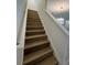 Elegant wooden staircase with white trim leading to the upper level of the home at 2137 Sunshine Peak Dr, Minneola, FL 34715