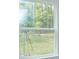 View of backyard from window, showcasing green grass and trees at 2137 Sunshine Peak Dr, Minneola, FL 34715
