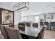 Modern dining room with dark wood table, brown leather chairs, and statement lighting at 2252 Juniper Berry Dr, Minneola, FL 34715