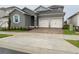 Two-story house with gray siding, light-colored garage doors, and a paved driveway at 2252 Juniper Berry Dr, Minneola, FL 34715