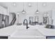 Modern kitchen island with white countertop, black sink, and pendant lighting at 2252 Juniper Berry Dr, Minneola, FL 34715