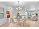 Elegant dining room features a glass-top table and white chairs near the kitchen at 233 Monterey St, Kissimmee, FL 34759