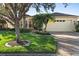 House with lush lawn, palm trees, and a brick driveway at 233 Monterey St, Kissimmee, FL 34759