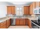 U-shaped kitchen with wood cabinets, granite countertops, and stainless steel appliances at 233 Monterey St, Kissimmee, FL 34759