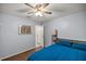 Calming bedroom showcasing a blue comforter, hardwood floors, and a minimalist design at 2937 Eagles Nest Rd, Fruitland Park, FL 34731