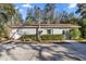 View of the home exterior, featuring neutral siding and an array of shrubbery at 2937 Eagles Nest Rd, Fruitland Park, FL 34731