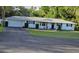 Charming single-story home with a manicured lawn, black shutters, and a two-car attached garage at 2937 Eagles Nest Rd, Fruitland Park, FL 34731