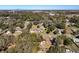 Aerial view of a house with a pool in a wooded neighborhood at 305 W Lady Lake Blvd, Lady Lake, FL 32159
