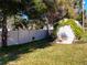 Landscaped backyard with detached garage and white fence at 305 W Lady Lake Blvd, Lady Lake, FL 32159