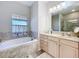 Relaxing bathroom with soaking tub, double vanity, and large mirror at 305 W Lady Lake Blvd, Lady Lake, FL 32159