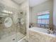 Spa-like bathroom with a walk-in shower and a soaking tub at 305 W Lady Lake Blvd, Lady Lake, FL 32159