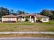 Single-story home with attractive landscaping and a welcoming front porch at 305 W Lady Lake Blvd, Lady Lake, FL 32159