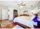 Main bedroom with king bed, hardwood floors, and en-suite bathroom at 305 W Lady Lake Blvd, Lady Lake, FL 32159