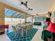 Covered patio with pool, table and chairs, and ceiling fans at 305 W Lady Lake Blvd, Lady Lake, FL 32159
