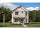 Two-story home with light beige siding, a teal door, and landscaping at 3150 Voyager Ave, St Cloud, FL 34771