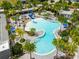 Aerial of community pool showcasing water slides, palm trees, lounge chairs, and relaxing amenities at 3150 Voyager Ave, St Cloud, FL 34771