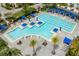 Aerial view of the community pool featuring a lap pool, lounge areas, and sun umbrellas for residents at 3150 Voyager Ave, St Cloud, FL 34771