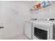 Bright laundry room with washer, dryer, and shelving at 410 Cheeota Ct, Minneola, FL 34715