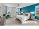 Spacious main bedroom with a large bed and a teal accent wall at 410 Cheeota Ct, Minneola, FL 34715