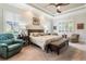 Bright Primary bedroom featuring a king-size bed and relaxing sitting area at 5072 Greens Dr, Lady Lake, FL 32159
