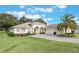 Single-story home with a two-car garage and well-manicured lawn at 5072 Greens Dr, Lady Lake, FL 32159