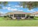 Single-story home with large backyard, screened patio, and landscaping at 5072 Greens Dr, Lady Lake, FL 32159