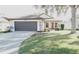 Single-story home with two-car garage and landscaped yard at 5622 Sir Churchill Dr, Leesburg, FL 34748