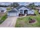 Single-story home with gray roof, white walls, and landscaped yard at 5626 Squires Dr, Leesburg, FL 34748