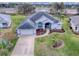 Aerial view of a house with a spacious lawn and lake view at 5626 Squires Dr, Leesburg, FL 34748