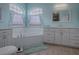 Elegant bathroom with double vanity, soaking tub, and large windows at 5626 Squires Dr, Leesburg, FL 34748