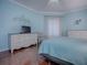 Serene bedroom featuring light blue walls, hardwood floors, and ample closet space at 5626 Squires Dr, Leesburg, FL 34748