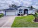 Front view of a charming house with a well-maintained lawn at 5626 Squires Dr, Leesburg, FL 34748
