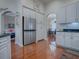 Kitchen with stainless steel refrigerator, white cabinets and view into dining area at 5626 Squires Dr, Leesburg, FL 34748