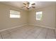 Empty bedroom with tile flooring, neutral walls, and ceiling fan at 6100 Windmill Rd, Leesburg, FL 34748