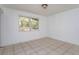 Empty bedroom featuring tile floors, white walls, and a window at 6100 Windmill Rd, Leesburg, FL 34748