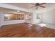 Spacious living room with laminate flooring, white walls, large windows, and a ceiling fan at 6100 Windmill Rd, Leesburg, FL 34748