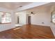 Open-concept living room with laminate wood flooring, white walls, and large windows offering ample natural light at 6100 Windmill Rd, Leesburg, FL 34748