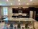 Spacious kitchen with dark cabinetry, granite countertops, and a large island at 8065 Penrose Pl, Wildwood, FL 34785
