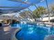 Inviting screened pool with a waterfall feature and brick pavers at 8415 Colony Barn Rd, Clermont, FL 34714