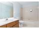 Clean bathroom with a bathtub, tiled walls and wood vanity at 9001 Village Green Blvd, Clermont, FL 34711