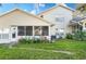 House exterior showcasing a screened porch, well-maintained lawn, and AC unit at 9001 Village Green Blvd, Clermont, FL 34711