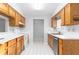 Bright kitchen featuring wood cabinets, white countertops, and appliances at 9001 Village Green Blvd, Clermont, FL 34711