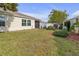 Spacious backyard with green lawn and screened patio at 906 Drakeswood Ave, The Villages, FL 32162