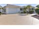 Front view of a single-story house with a attached garage and landscaped yard at 906 Drakeswood Ave, The Villages, FL 32162