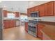 Kitchen with wood cabinets, granite countertops, and stainless steel appliances at 906 Drakeswood Ave, The Villages, FL 32162