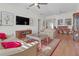 Open living space with hardwood floors, a beige sofa, and access to the dining area at 906 Drakeswood Ave, The Villages, FL 32162